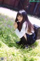 A young woman sitting in a field of flowers.