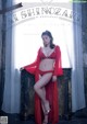 A woman in a red lingerie posing in front of a window.