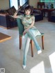 A woman sitting on a chair holding a fan.