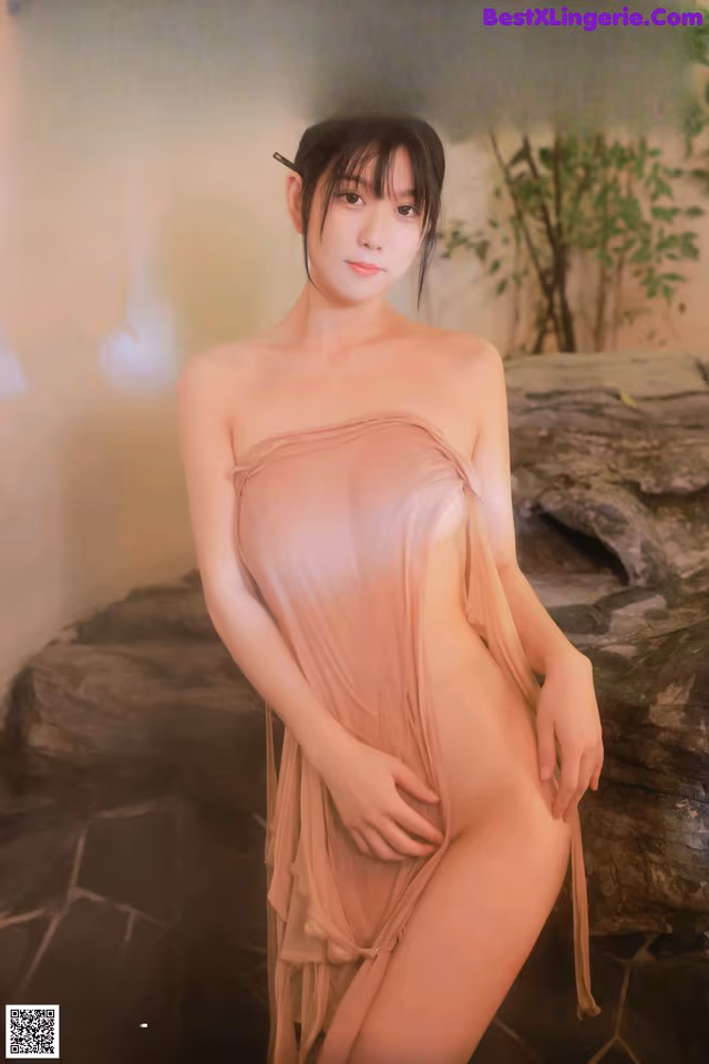 a woman in a pink dress posing for the camera