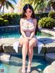 A woman sitting on the edge of a swimming pool.