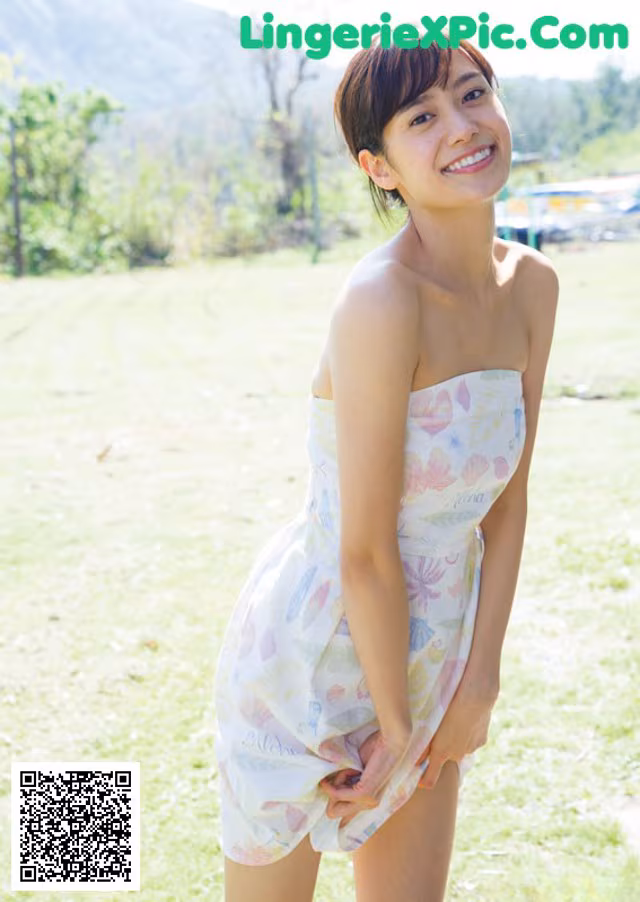 A woman in a white dress standing in a field.