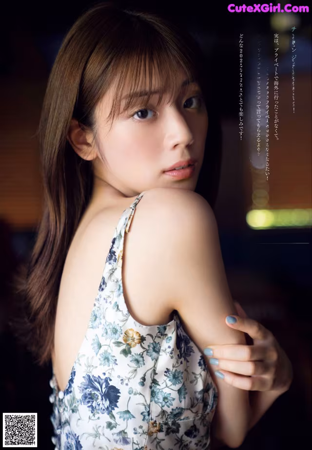 A woman in a floral dress posing for a magazine.