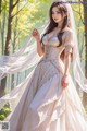 A woman in a wedding dress standing in the woods.