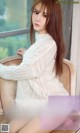 a woman sitting on top of a chair next to a window